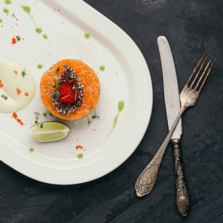 Salmon tartare in cheese sauce with avocado and flying fish caviar in Pegas